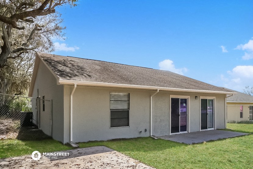 a small white house with a yard and a tree