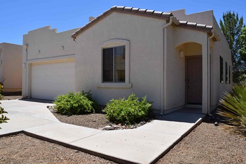 A house with a white garage door and a brown door.