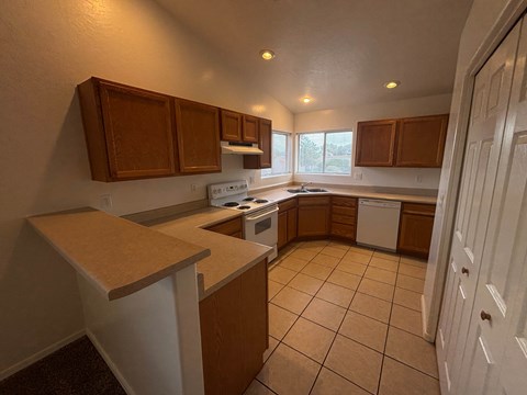 A kitchen with brown cabinets and white appliances.