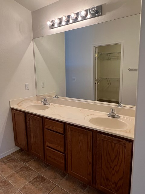 a bathroom with two sinks and a large mirror