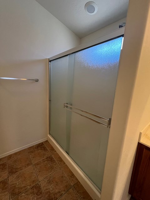 a shower with a glass door in a bathroom