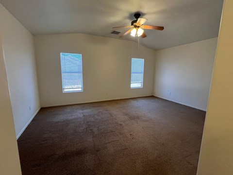 the living room of an empty house with a ceiling fan