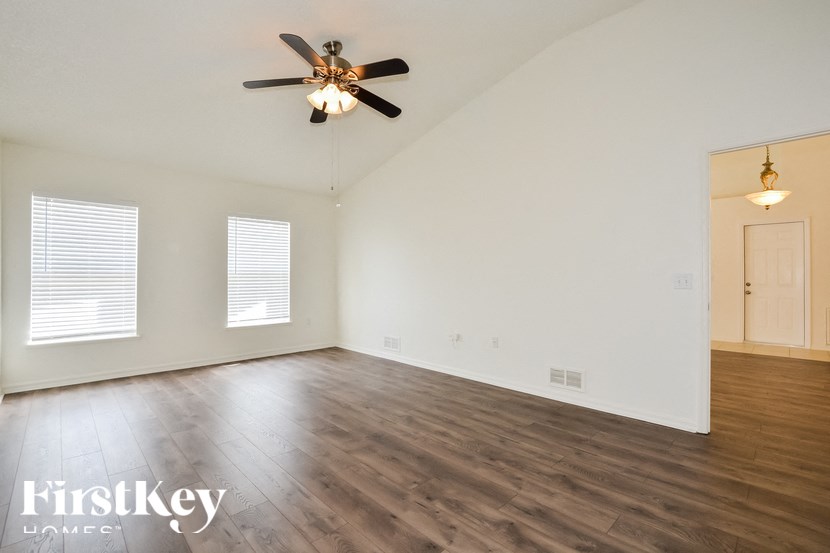 a living room with wood floors and a ceiling fan