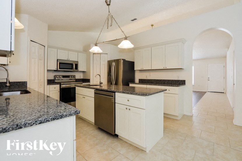 a large kitchen with granite counter tops and white cabinets