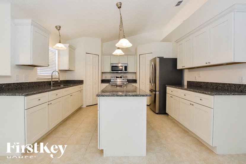 a large kitchen with white cabinets and granite counter tops