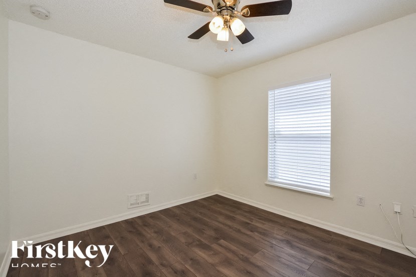 the living room of an empty house with a ceiling fan