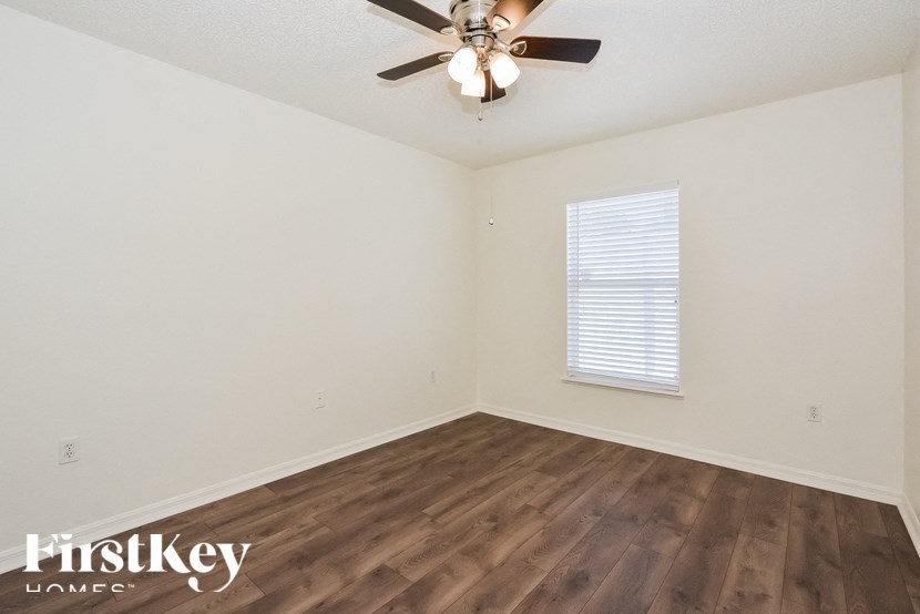 a bedroom with hardwood flooring and a ceiling fan
