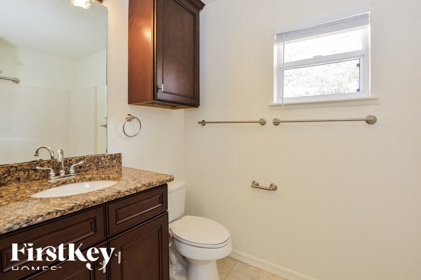 a bathroom with a toilet and a sink and a window