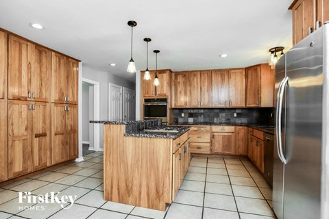 a kitchen with wooden cabinets and a stainless steel refrigerator