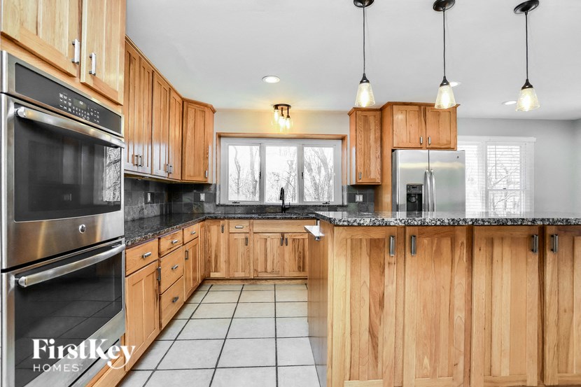 a large kitchen with wooden cabinets and black counter tops