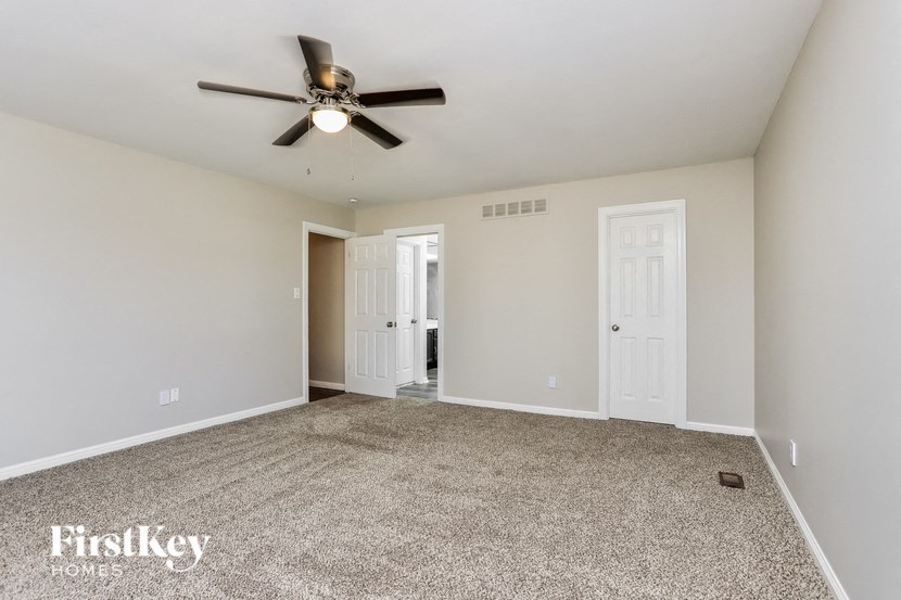 an empty living room with a ceiling fan