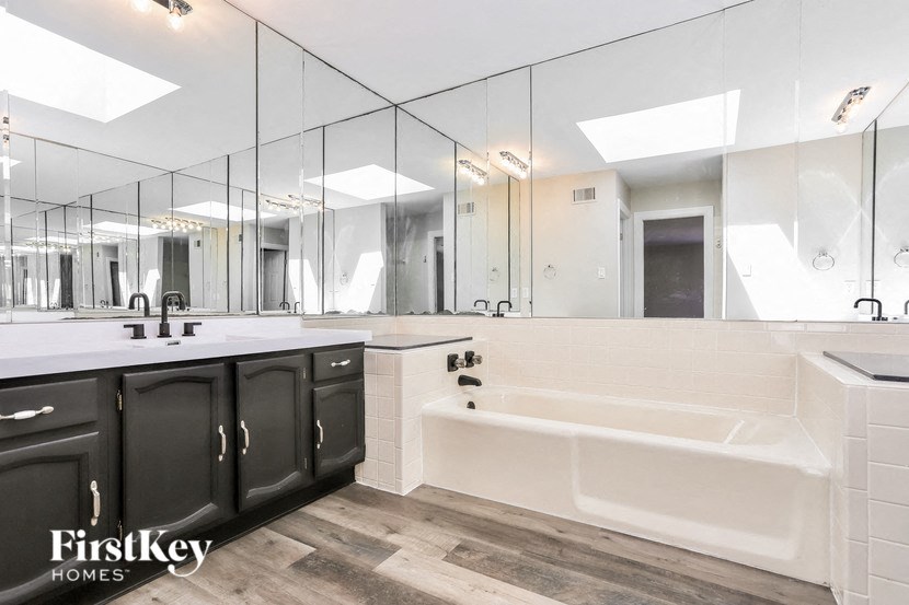 a bathroom with a tub and a sink and a mirror