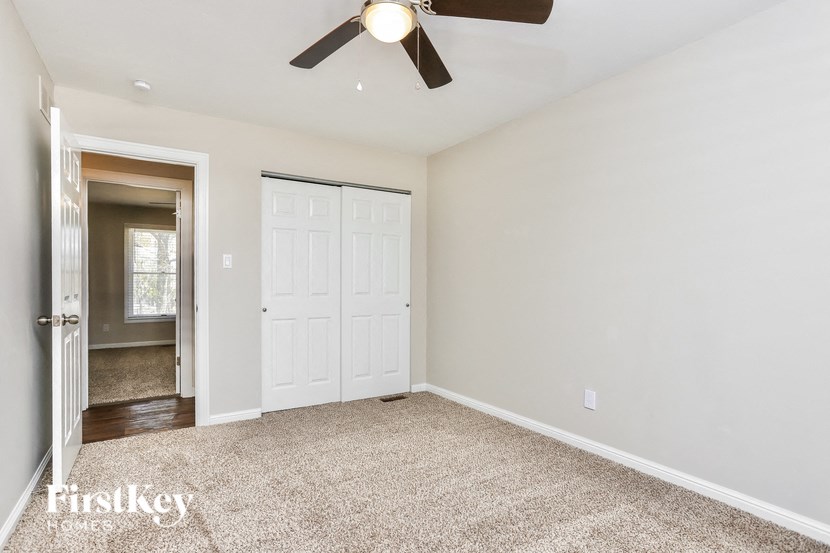 a empty room with a ceiling fan and a closet