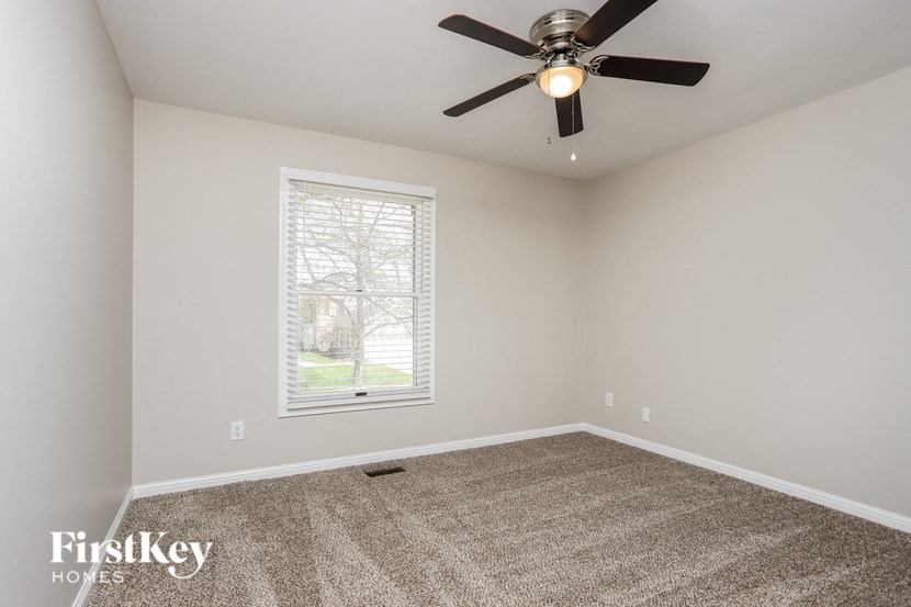 a empty room with a ceiling fan and a window