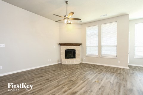 a living room with a fireplace and a ceiling fan