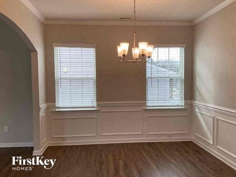 a dining room with a chandelier and two windows