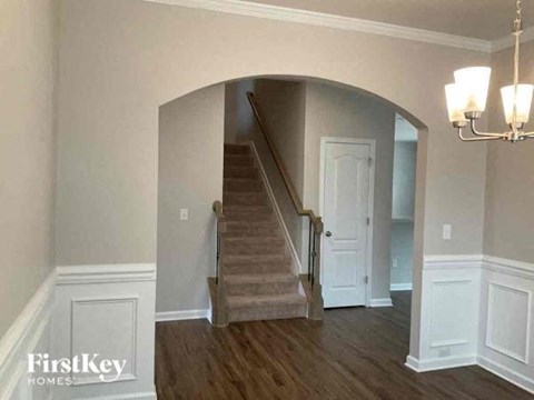 a living room with a staircase and a white door