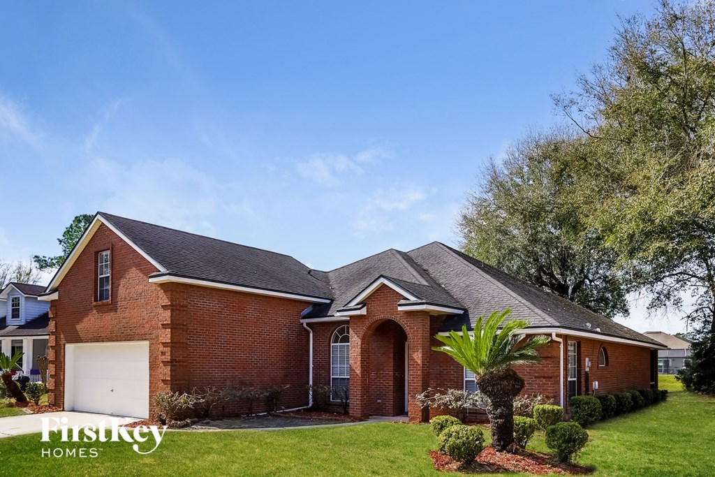 a brick house with a palm tree in the yard