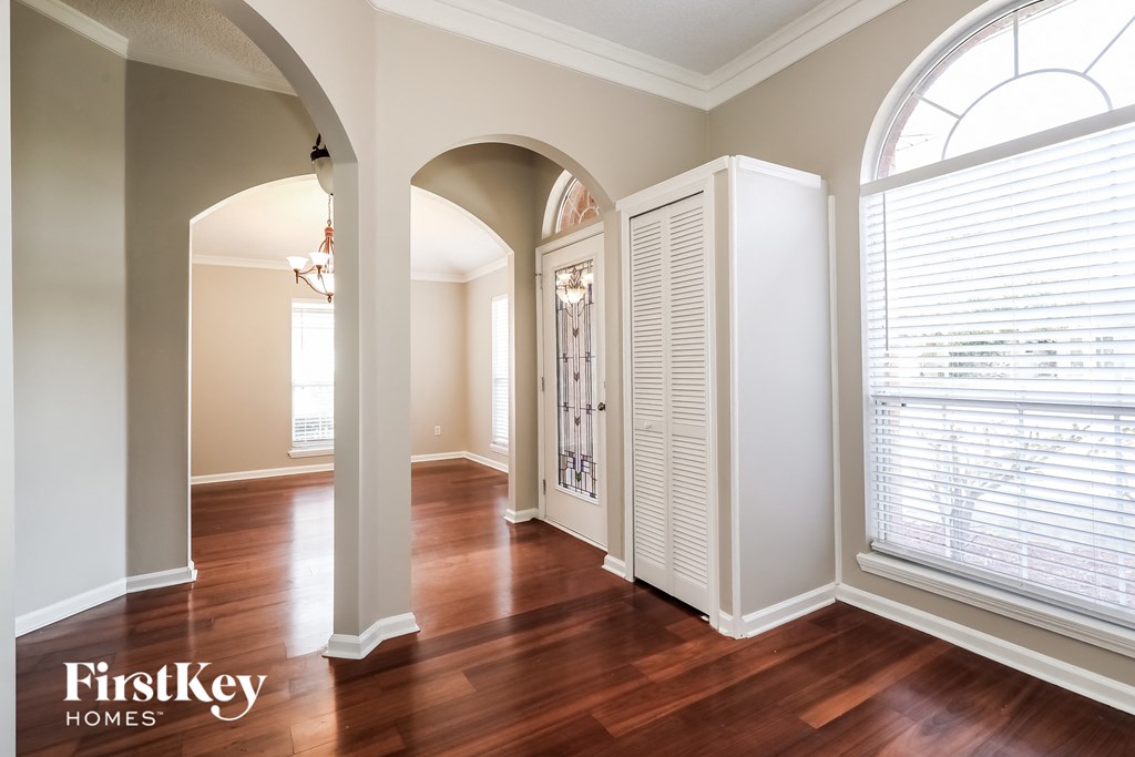 a living room with a large window and wood floors