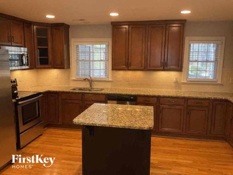 A kitchen with wooden cabinets and a granite countertop.