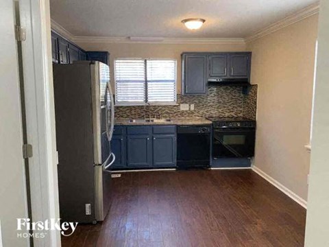 a kitchen with blue cabinets and a stove and a refrigerator