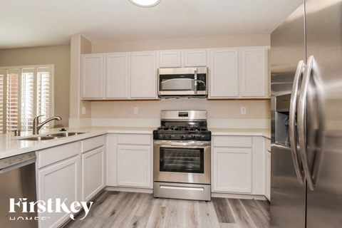 A kitchen with white cabinets and stainless steel appliances.