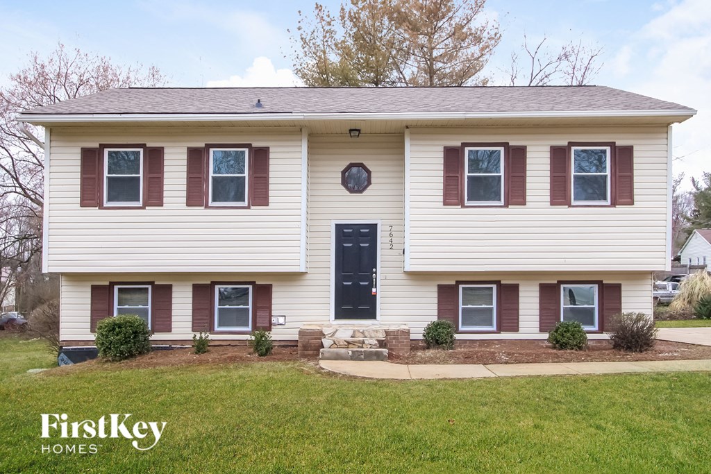 a white house with burgundy shutters and a blue door
