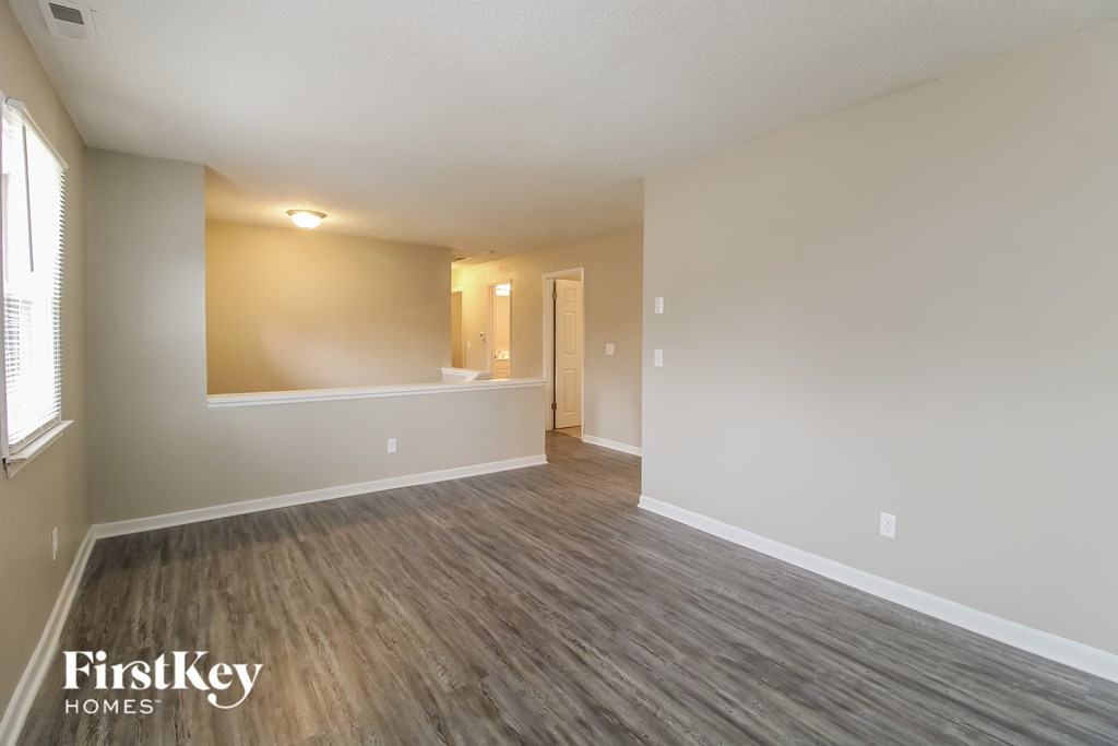 an empty living room with wood flooring and a large window