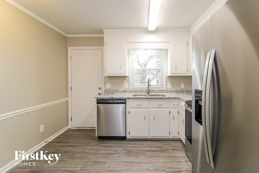 a kitchen with white cabinets and stainless steel appliances