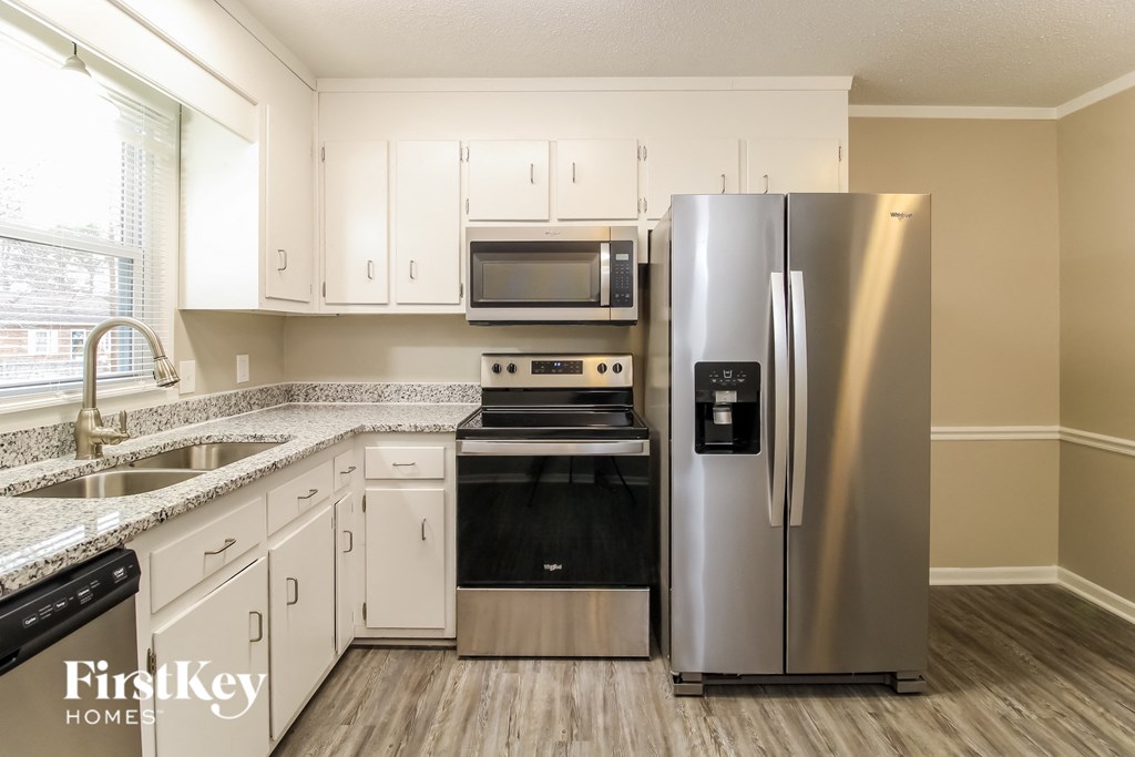 a kitchen with stainless steel appliances and white cabinets
