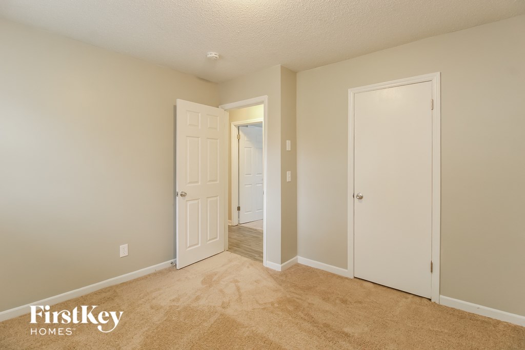 a bedroom with a closet and a door to a hallway