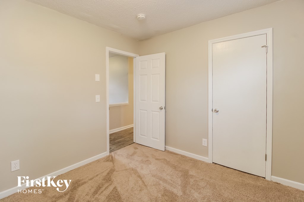 a bedroom with a closet and a door to a hallway
