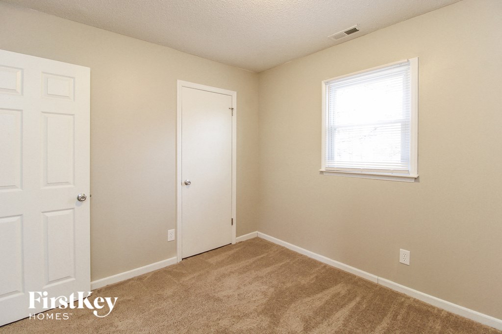 a bedroom with a closet and a door and a window