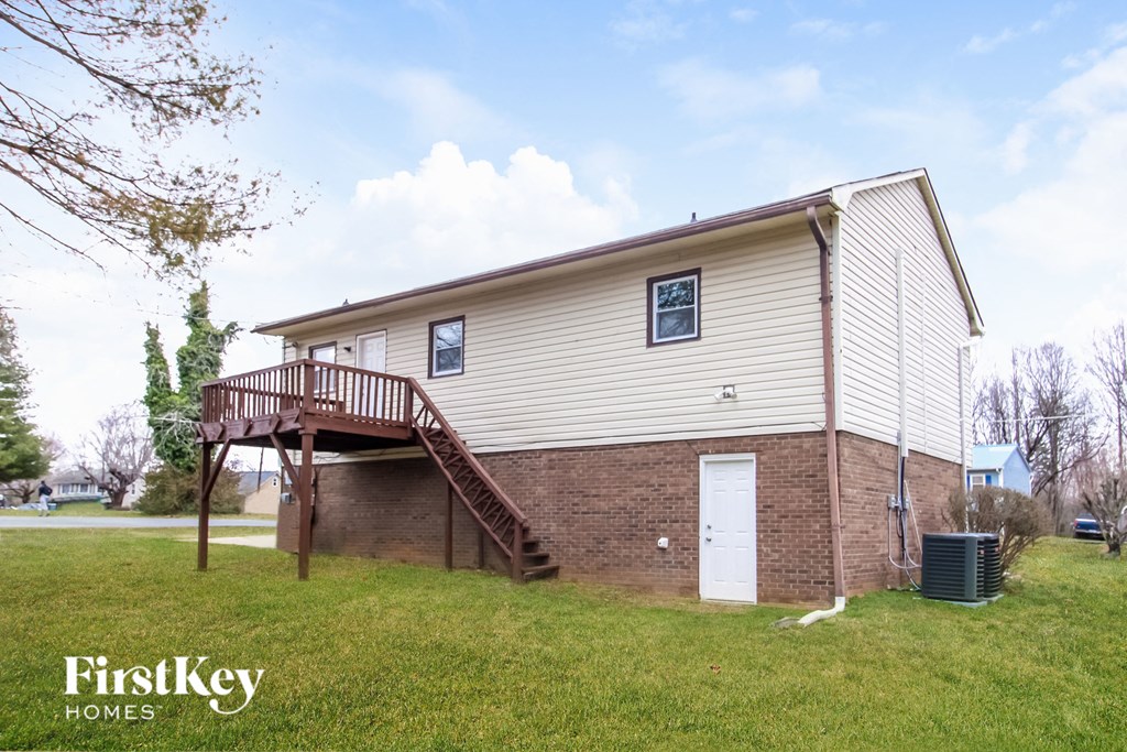 the front of a house with a deck and a brick wall