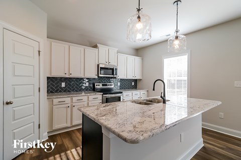 A kitchen with a marble countertop and a sink.