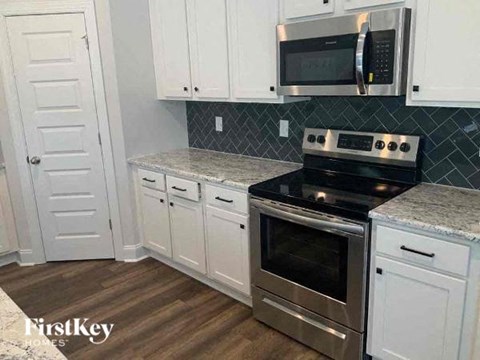 A kitchen with white cabinets and a stainless steel oven.