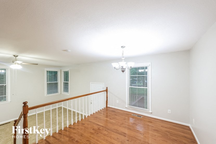 a living room with a staircase and a wood floor