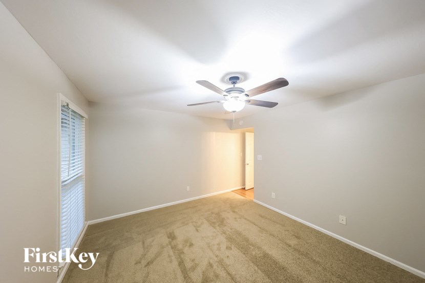 a empty room with a ceiling fan and a window