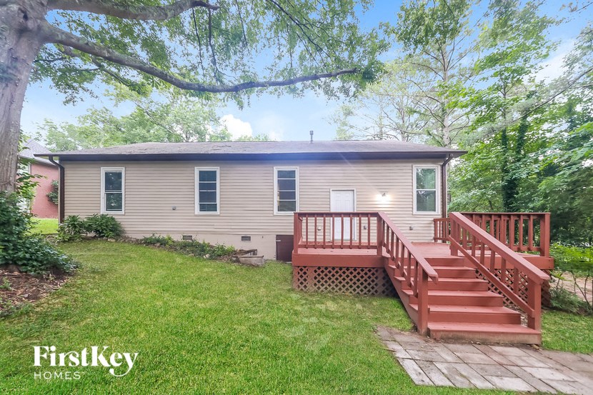 a house with a wooden deck and a yard with stairs