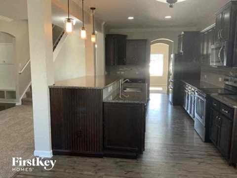 A kitchen with dark wood cabinets and a stainless steel refrigerator.