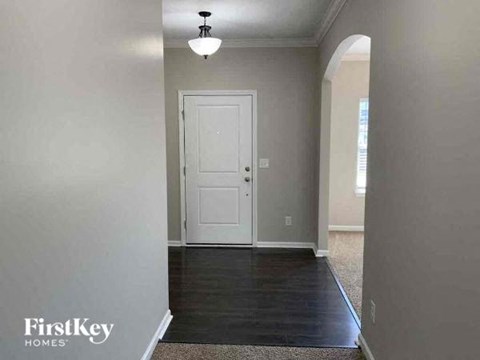 A room with a white door and a light on the ceiling.