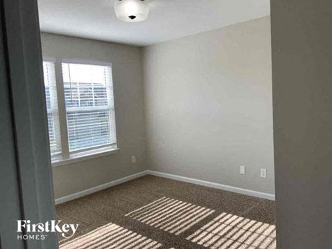 A room with a window and a carpet on the floor.