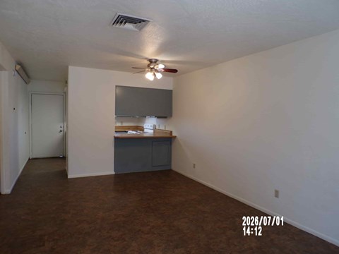 A room with a ceiling fan and a cabinet.
