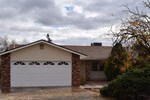 A house with a white garage door and a brick chimney.