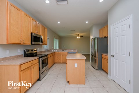 a large kitchen with wooden cabinets and stainless steel appliances