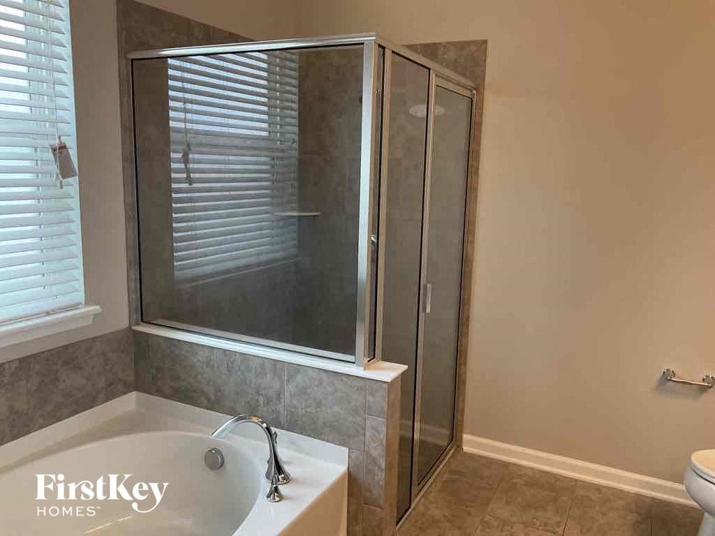 a small bathroom with a shower and a bath tub