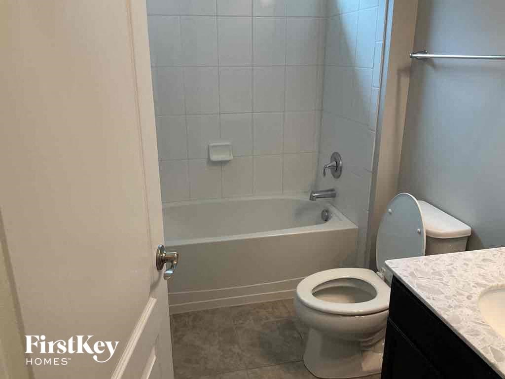 a bathroom with a toilet and a tub and a sink