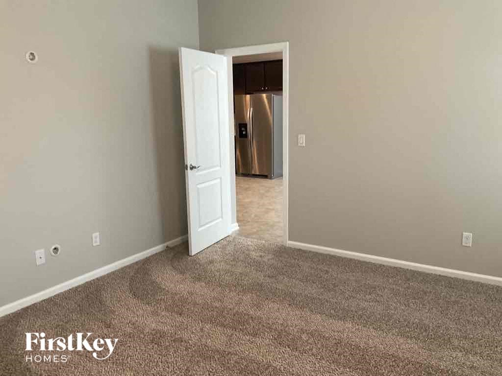 a carpeted room with a door open to a closet