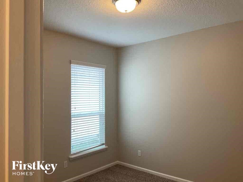 an empty room with a window and a light on the ceiling