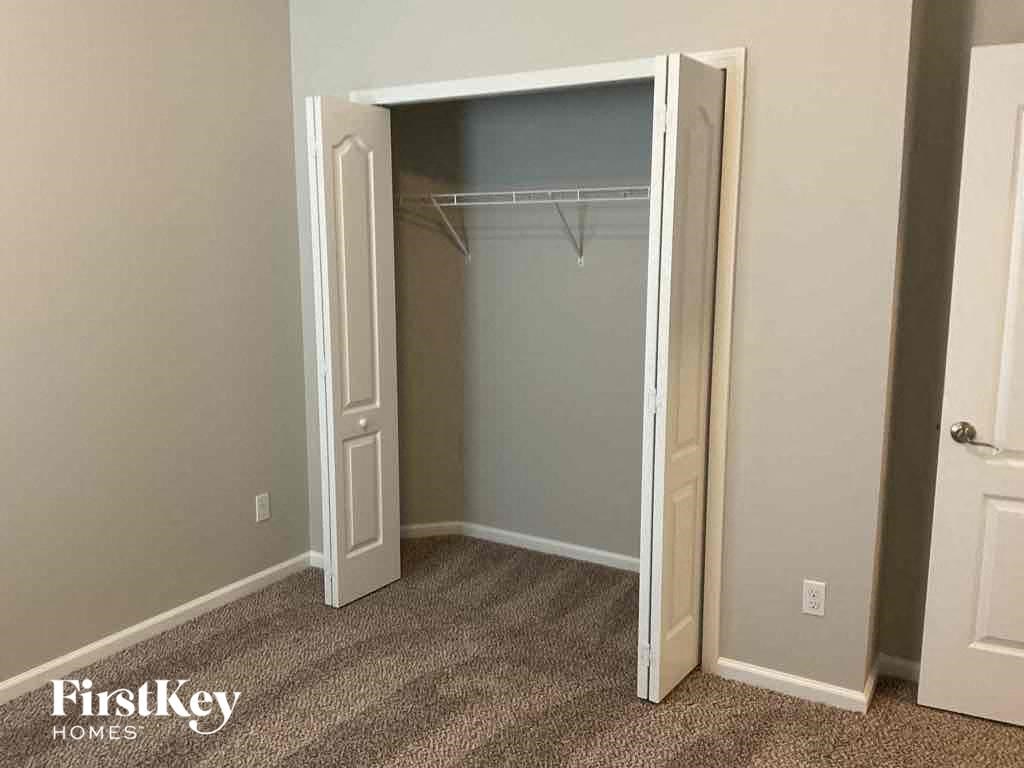 an empty closet in a bedroom with a white closet door